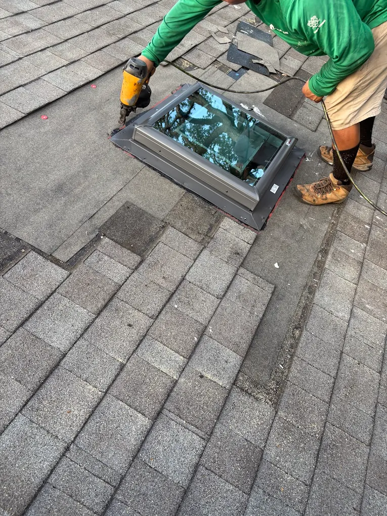 Technician securing skylight flashing during installation.