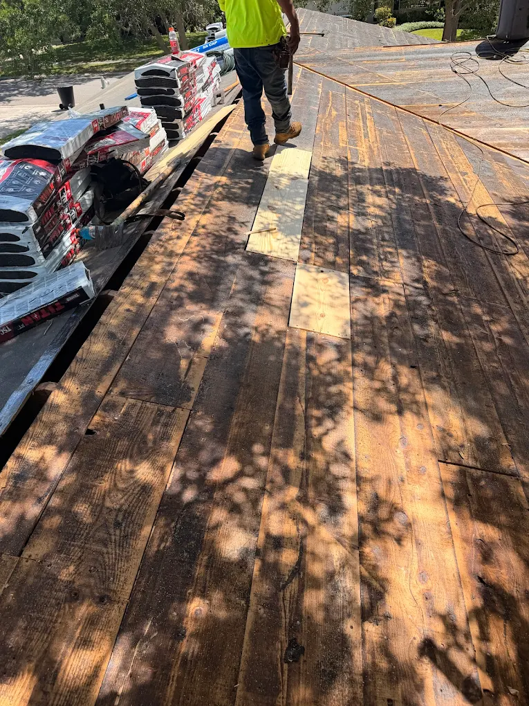Roof deck repairs underway with replacement boards set in place.